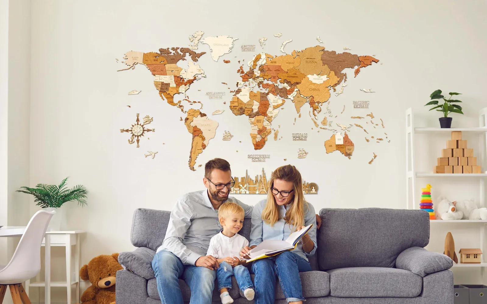 Manufacturer image used for editorial comparison; source and rights metadata retained in the image library. A family beneath a layered wooden world map with islands and decorative accessories