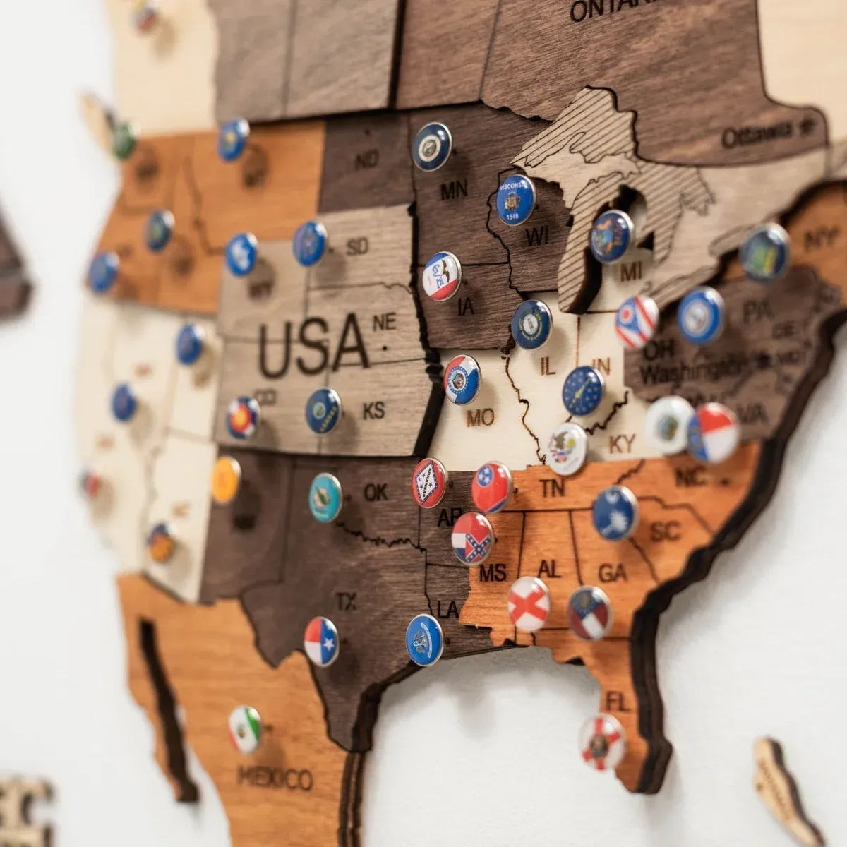 Manufacturer image used for editorial comparison; source and rights metadata retained in the image library. Close-up of an engraved Enjoy The Wood map with flag pins marking locations