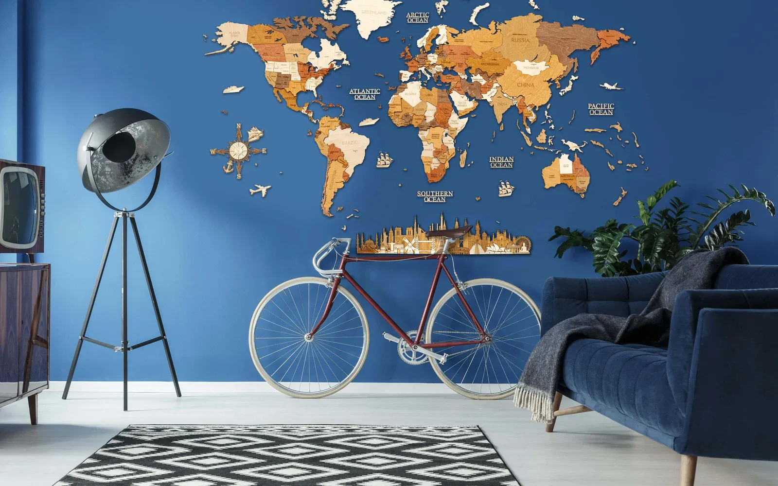 Multitone wooden world map with separate islands above a bicycle on a blue living-room wall